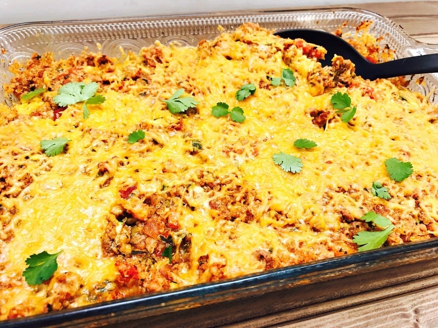 Glass casserole dish with a finished Turkey Quinoa Taco Bake topped with cilantro.