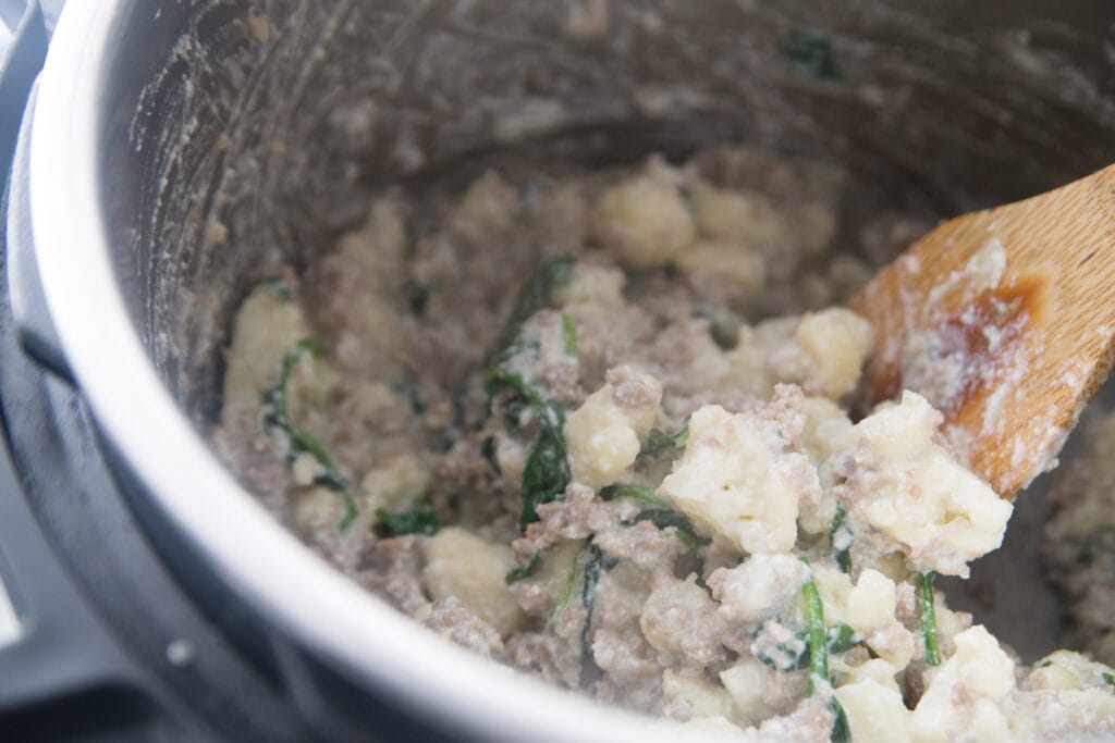 An Instant Pot with sausage and cauliflower casserole made with ricotta and parmesean cheese 