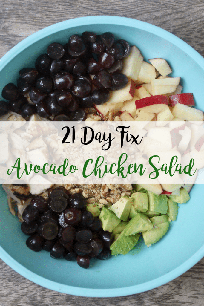 Diced chicken, sliced graps, diced walnuts, diced appples, and diced avocados sit in a  blue bowl, unmixed on a wooden surface- with the text overlay 21 Day Fix Avocado Chicken Salad