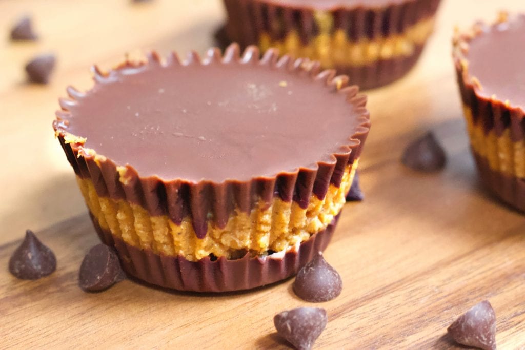 Homemade pumpkin chocolate cups on a wooden table 