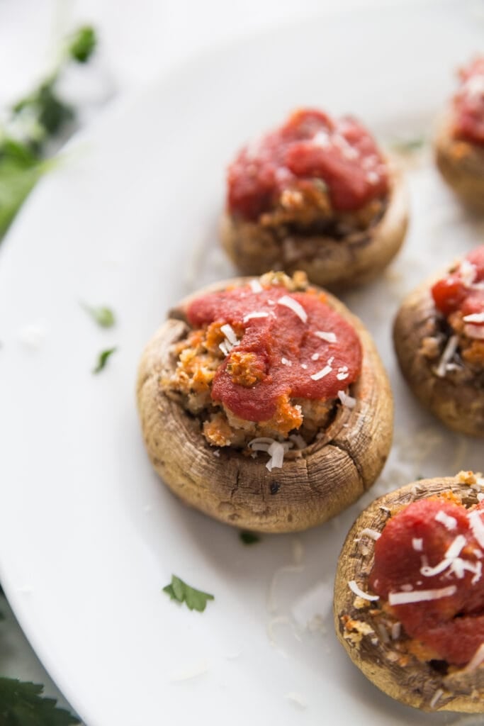 Close up photo of Italian stuffed mushrooms on a white plate, ready for brunch