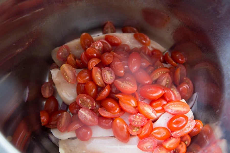 Chicken in Instant Pot topped with tomatoes 