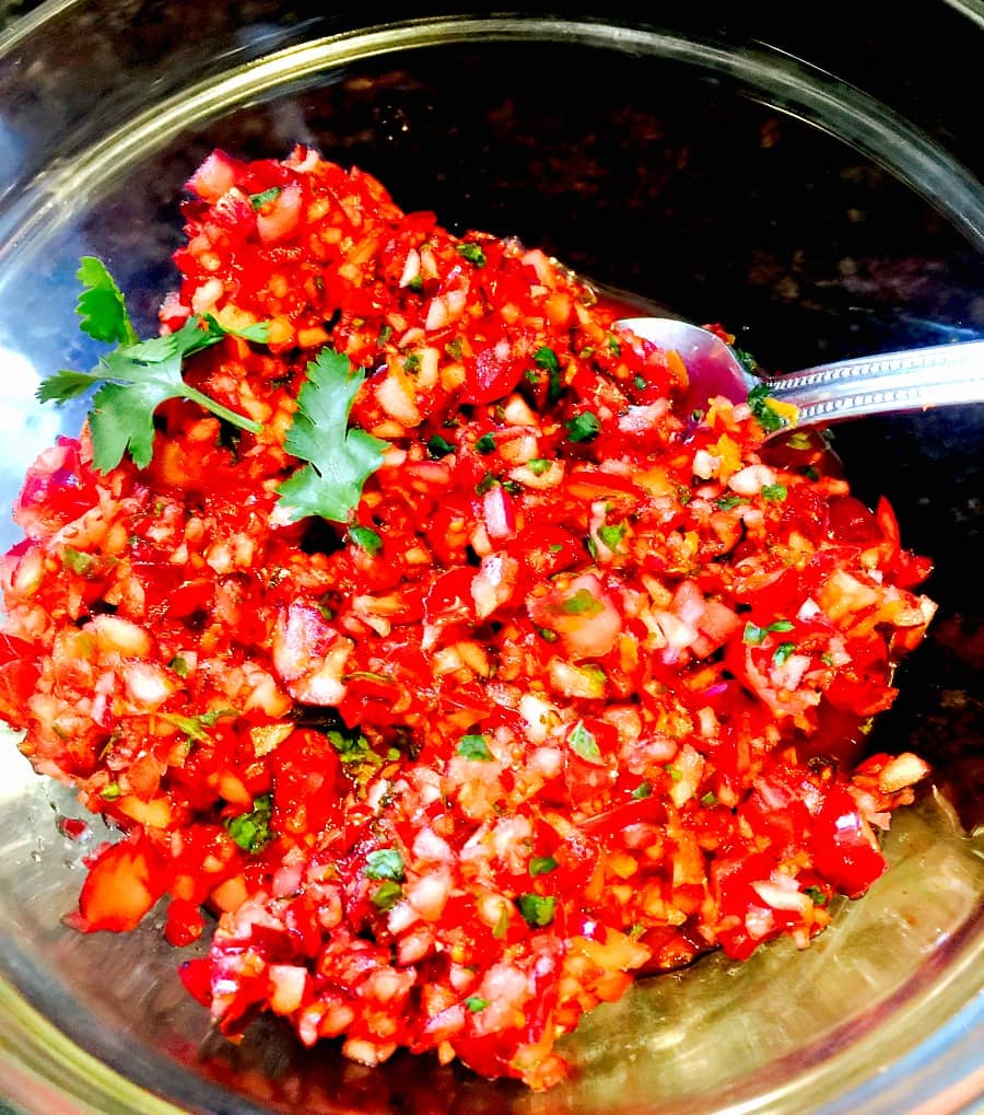 Finished Cranberry Salsa in a glass bowl with a serving spoon