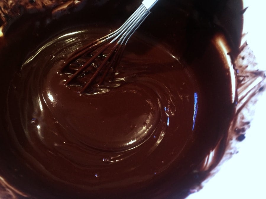 Melted coconut oil, cocoa powder, and sweetener being whisked together.