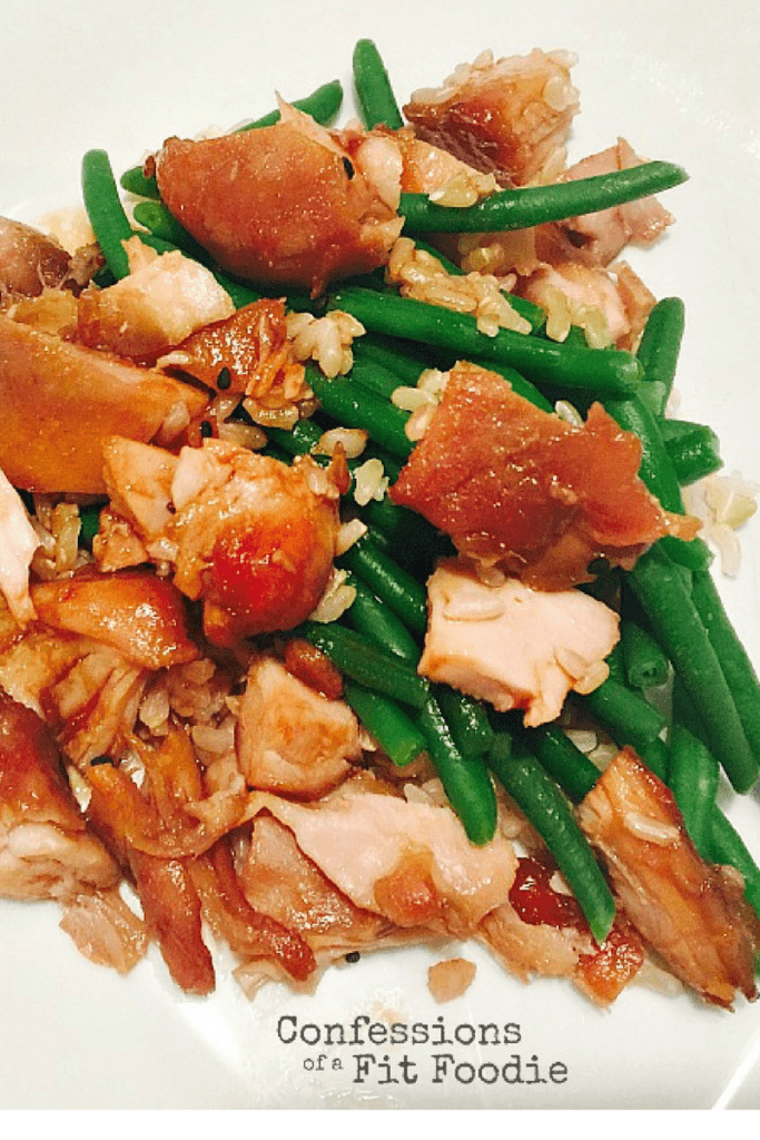Overhead photo of diced asian chicken thighs over rice and green beans.