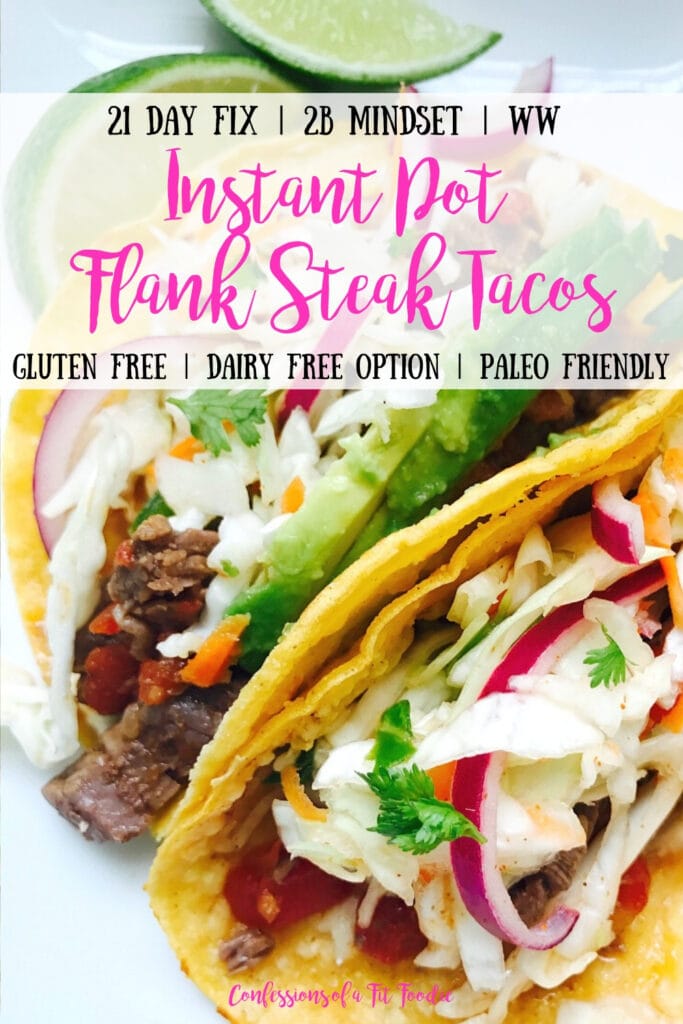 Two Instant Pot Flank Steak Tacos sit propped side by side on a white plate with limes in the background. In the tacos are flank steak, cilantro lime slaw, and topped with cilantro and avocado. There is a text overlay- 21 Day Fix | 2B Mindset | WW | Instant Pot Flank Steak Tacos | Gluten Free | Dairy Free Option | Paleo Friendly