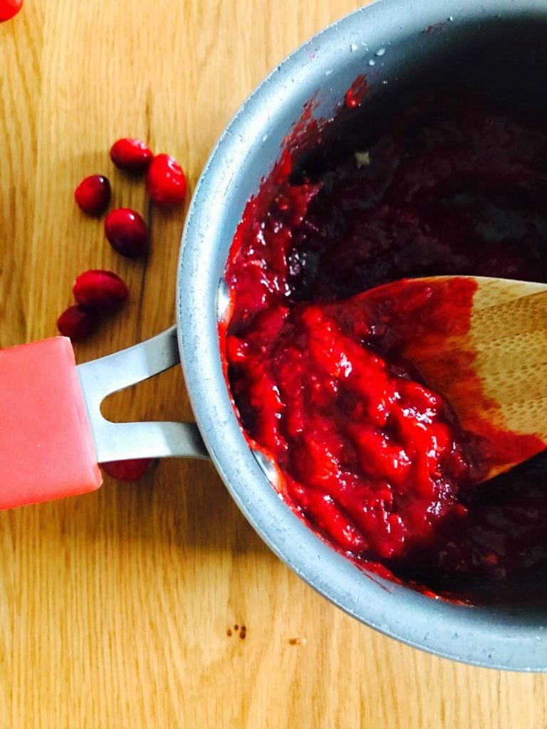 Cranberry Horseradish Chutney in a sauce pan with a wooden spoon