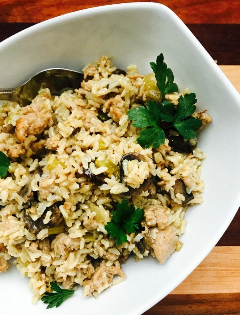 An overhead photo of a white rectangular bowl full of gluten free Stuffing made with brown rice and sausage.