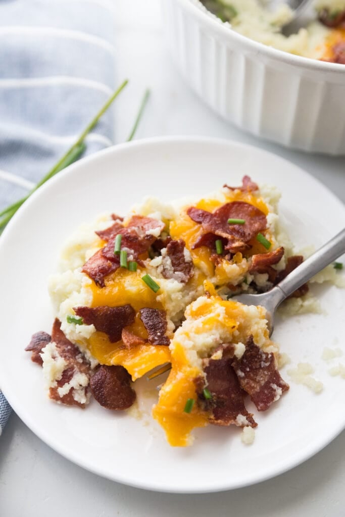 A small plate of Loaded Cauliflower Mashed Potatoes with bacon, cheddar, and chives. 