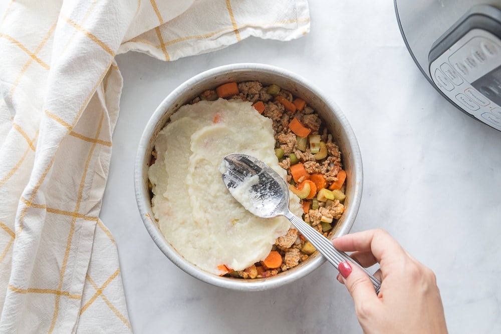 Aluminum plate with healthy shepherd's pie topped with mashed cauliflower and mashed potatoes sitting near an Instant Pot