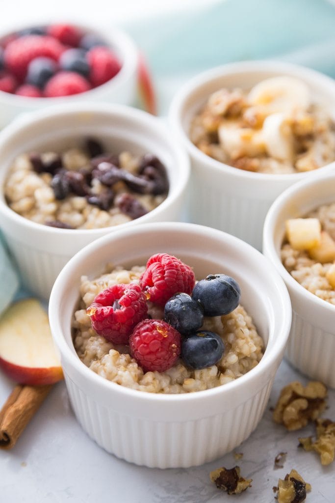 Four bowls of Instant Pot Steel Cut Oats with various fruit toppings