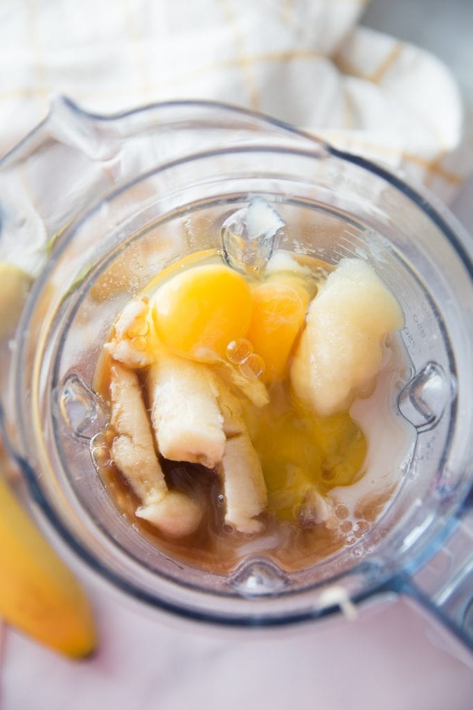 A blender with bananas, eggs, milk and maple syrup 