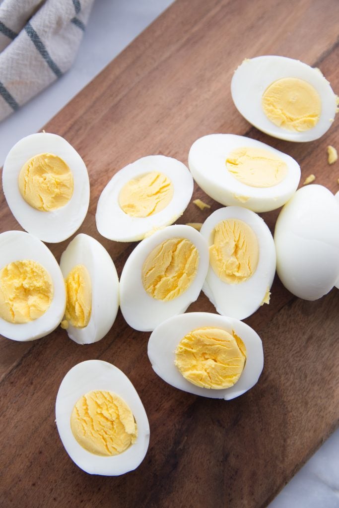 Halved hard boiled eggs on a wooden cutting board