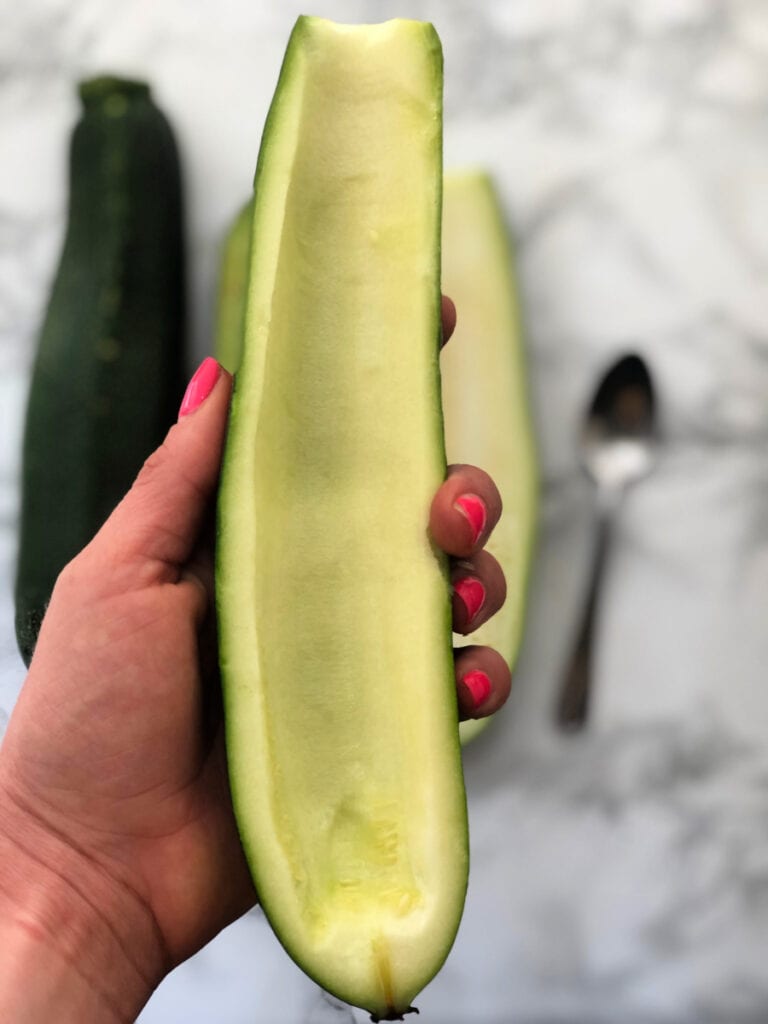 A zucchini with the inside flesh scooped out - being used for zucchini boats