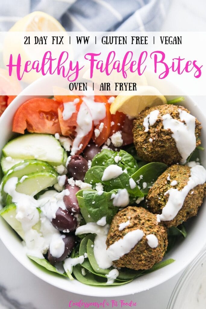 Overhead photo of large white bowl filled with Falafel bites and veggies including spinach, cucumbers, tomatoes, and olives, topped with tzatziki dressing with lemon wedges on the side; with the text overlay, 21 Day Fix | WW | Gluten Free | Vegan | Healthy Falafel Bites | Oven | Air Fryer