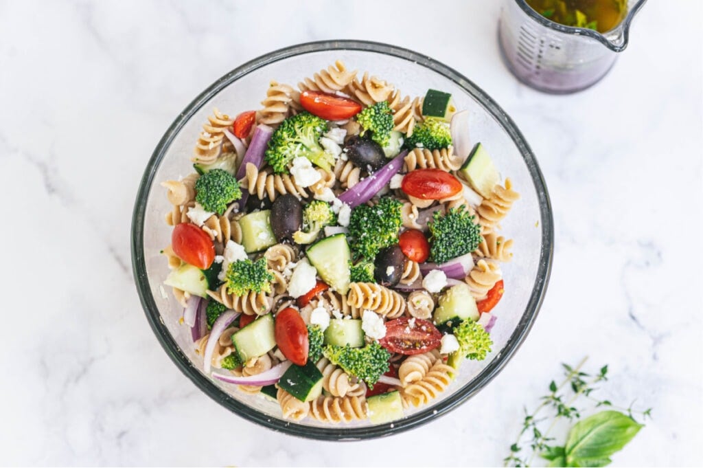 Overhead photo of glass serving bowl of Greek pasta salad