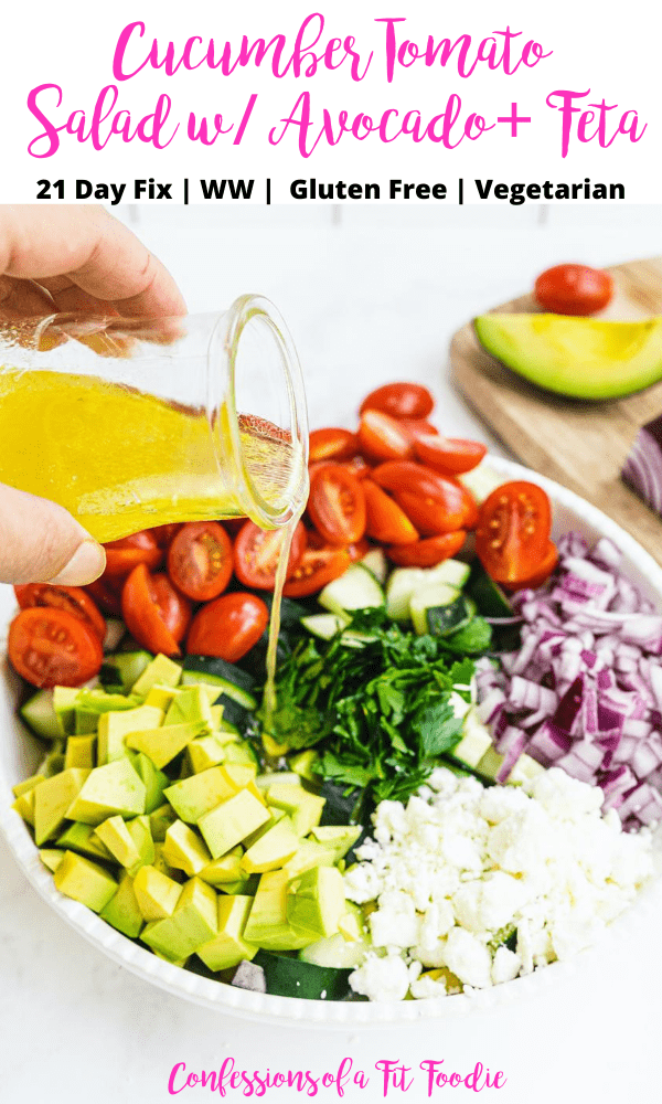 A bowl of summer salad with dressing being poured over the top with a black and pink text overlay. The text says- Cucumber Tomato Salad w/ Avocado + Feta | 21 Day Fix | WW | Gluten Free | Vegetarian | Confessions of a Fit Foodie