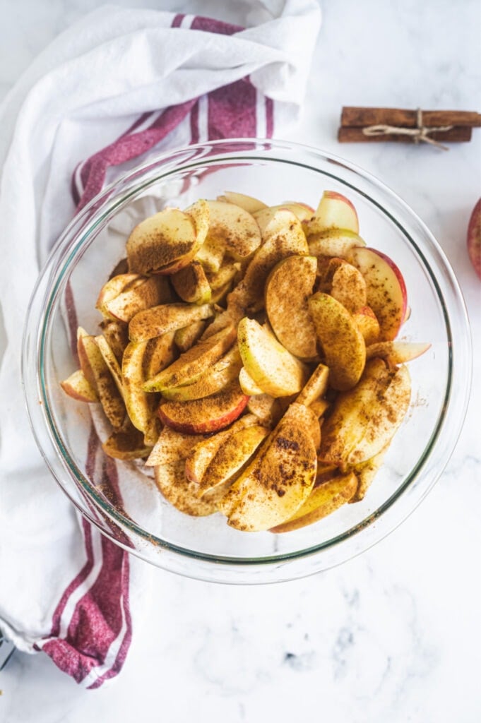 Sliced apples with cinnamon in a glass bowl