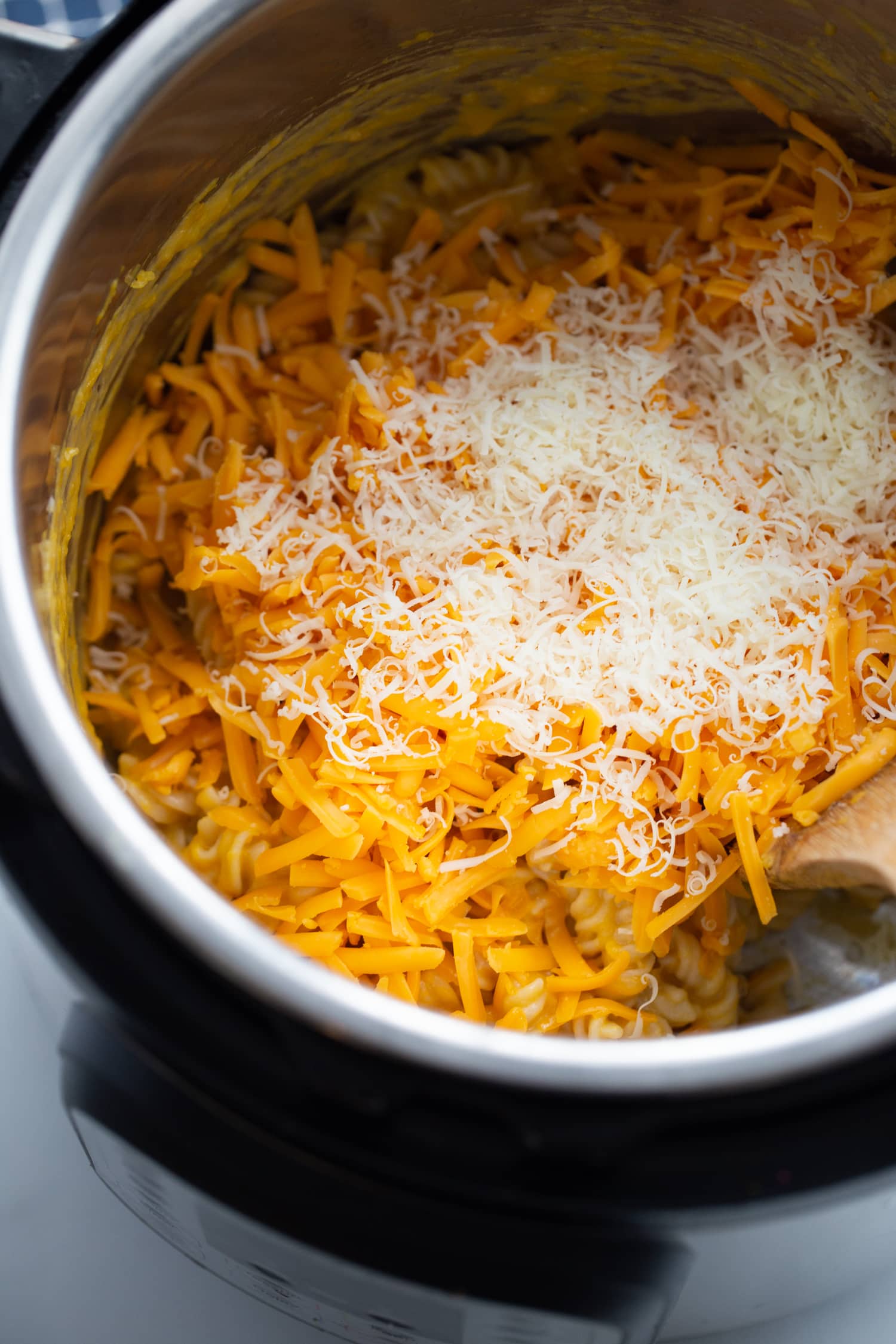 Overhead photo of shredded cheese, cooked pasta, and butternut squash ready to be mixed in the instant pot