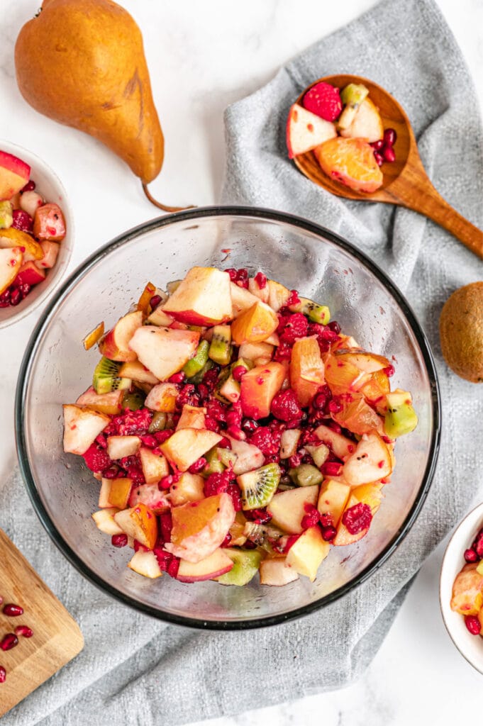 All fruits have been mixed together with a wooden spoon, creating a ready to serve winter fruit salad.