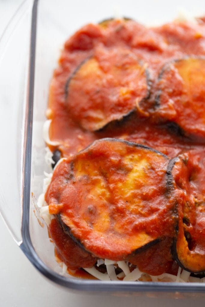 Tomato sauce covers several layers of eggplant slices.