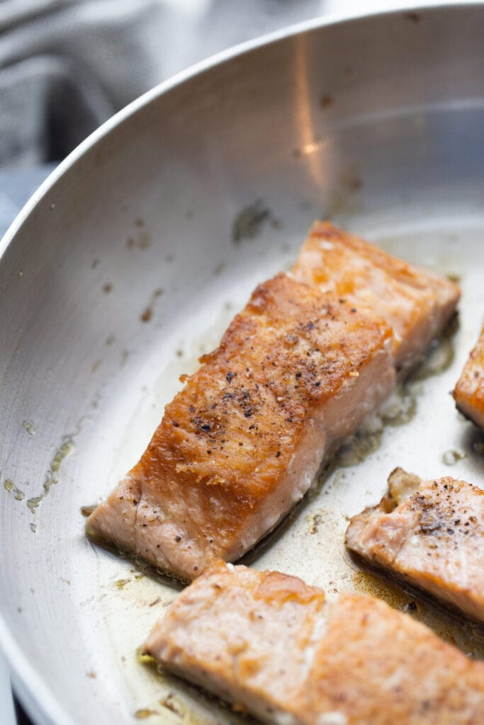 Crispy salmon fillets cooked stovetop in a pan