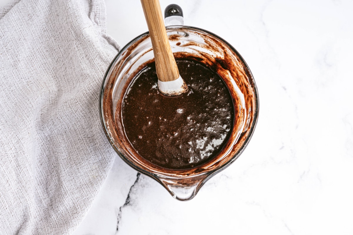 Fudgy homemade brownie mix in a large handled glass measuring cup