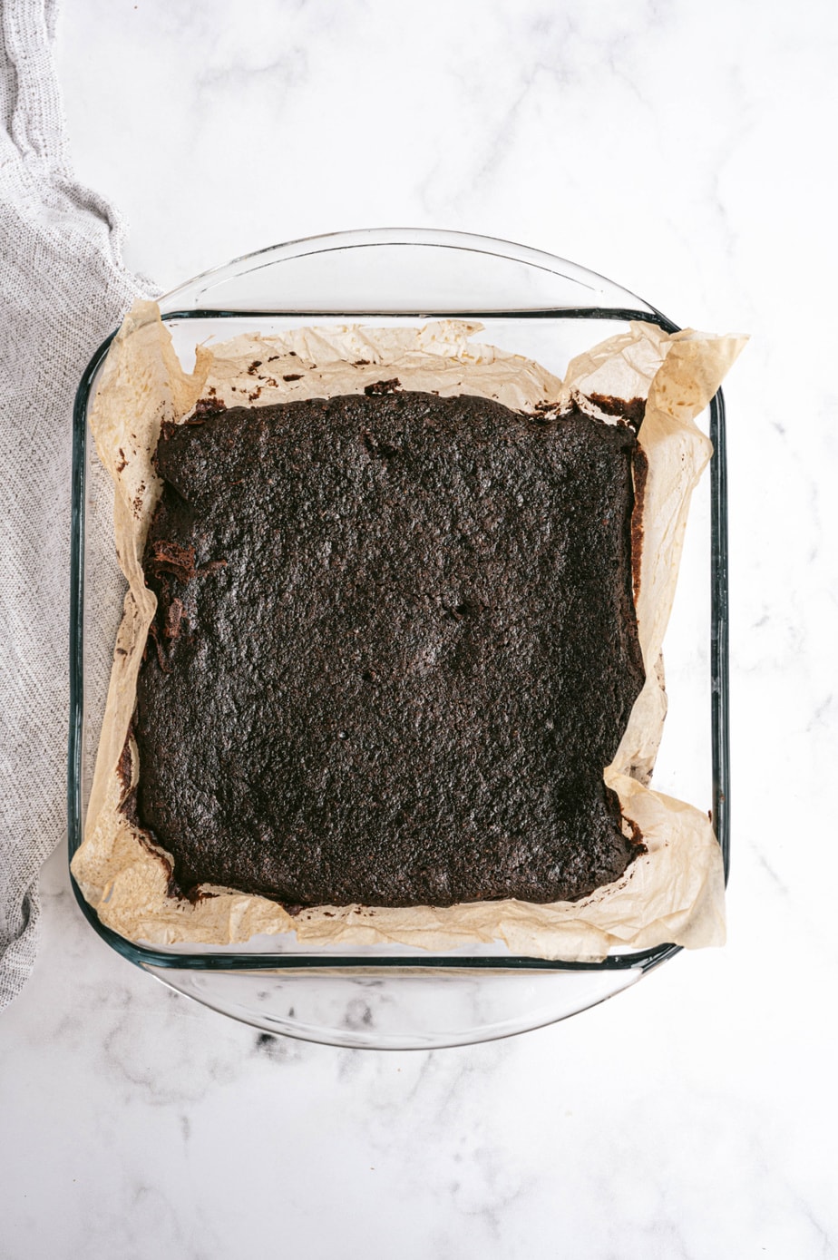Entire parchment lined glass pan of brownies, straight out of the oven 