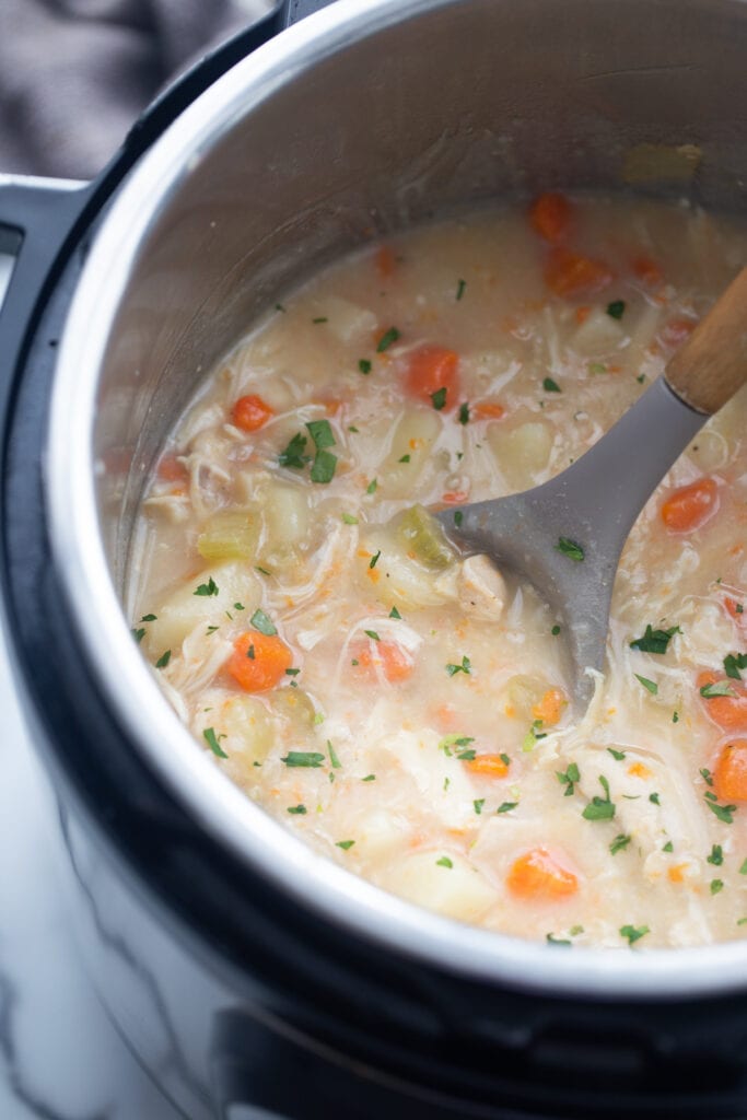 A pot full of chicken pot pie soup is ready to be eaten.