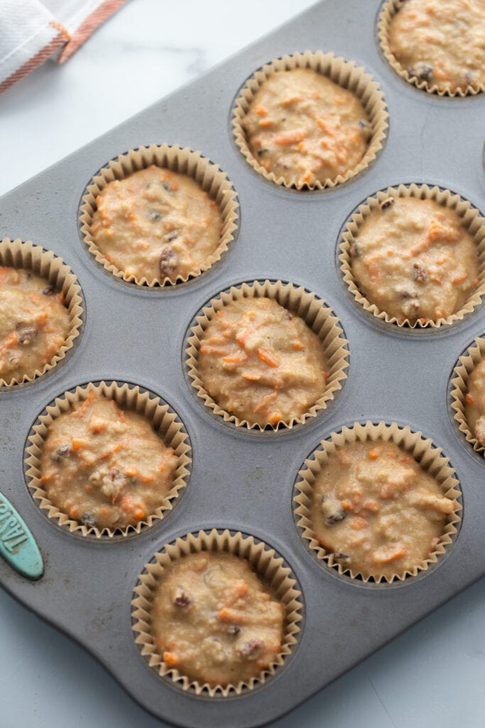 Muffin tin with carrot cake muffin batter, ready for the oven.