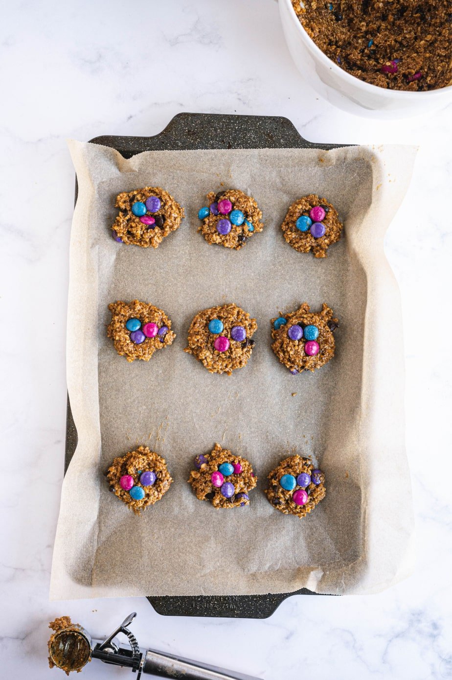Nine cookies are on a prepared baking sheet.