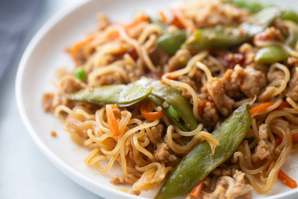 Close up photo of ramen noodles with stir fry veggies and ground chicken