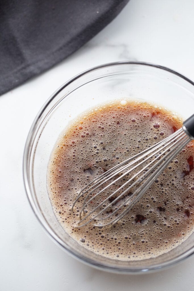 Stir fry sauce in a glass bowl with a whisk