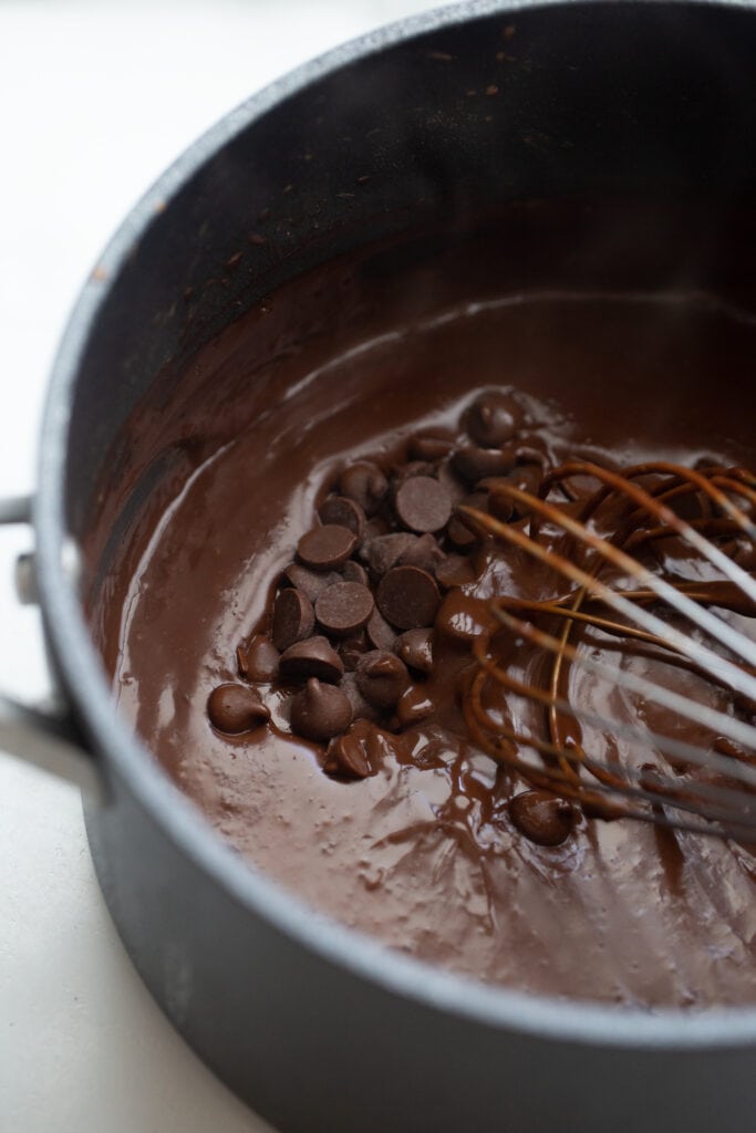 Whisking dairy free chocolate chips into a pot of pudding