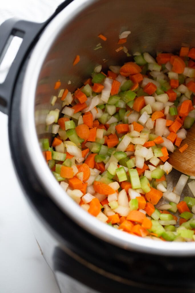 Overhead photo of chopped carrots, celery, and onion in an instant pot.