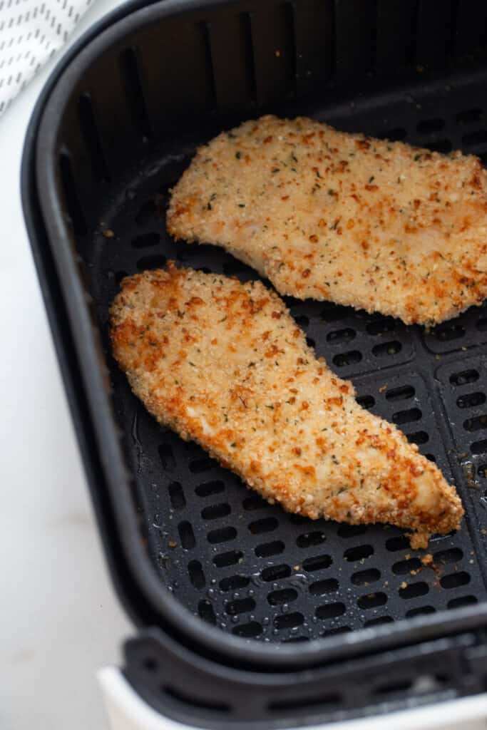Close up of Air Fryer Chicken Cutlets in a square air fryer basket 