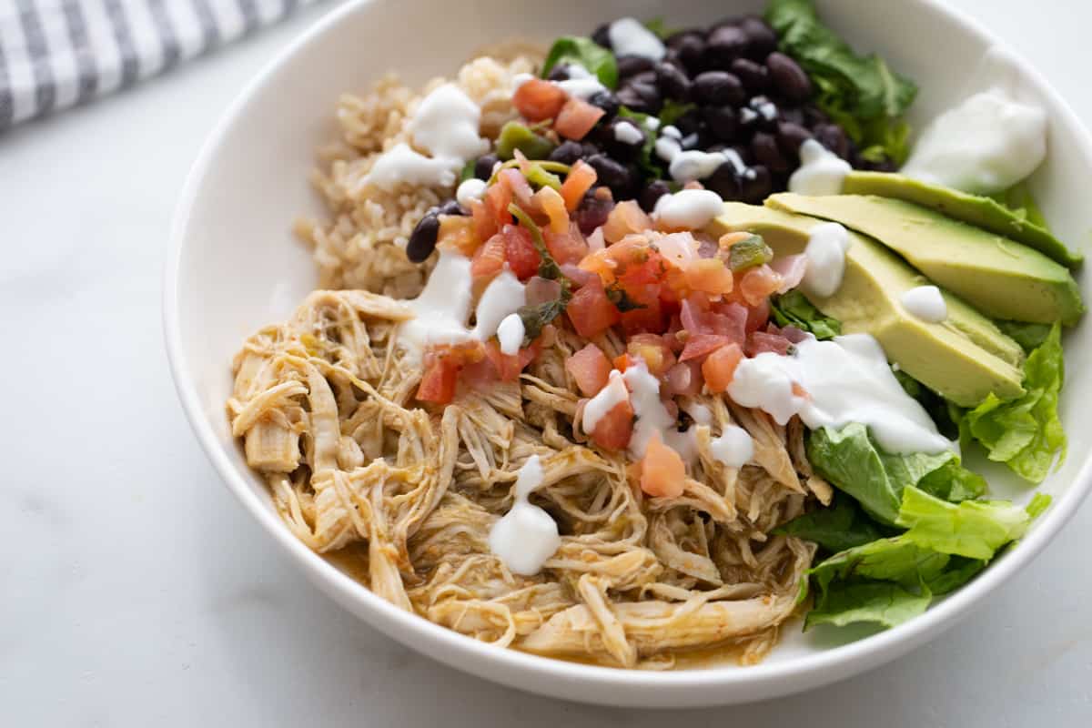 A burrito bowl of salsa lime chicken with toppings. 