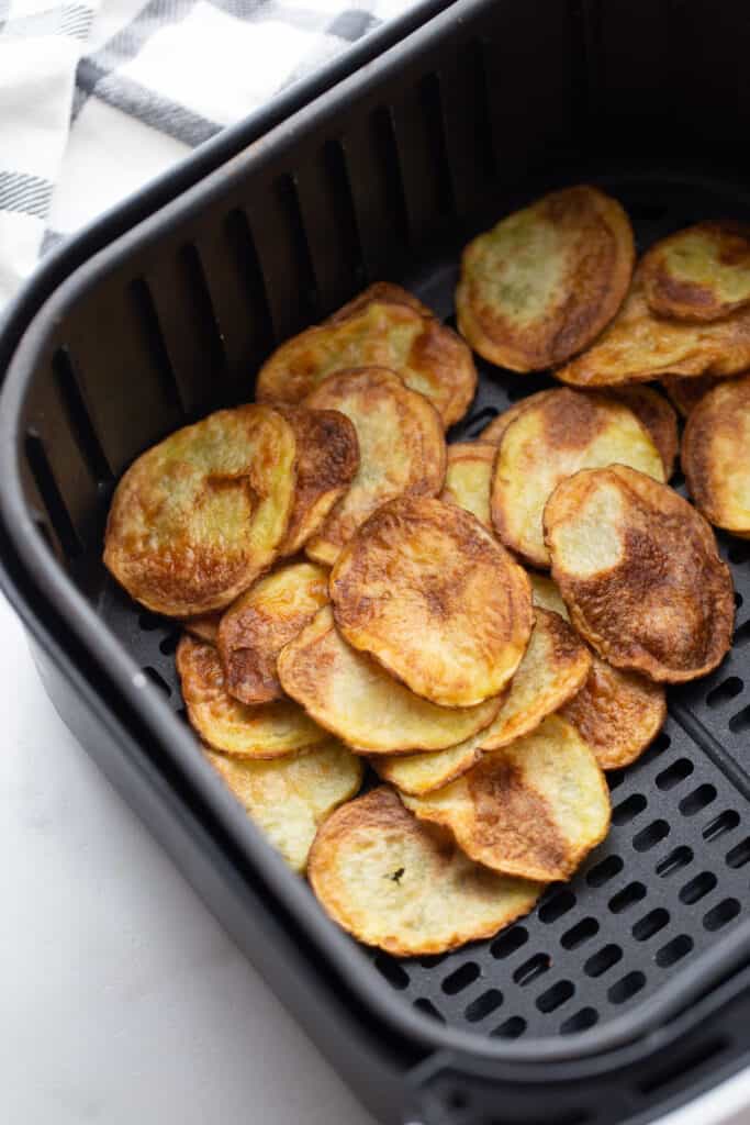 Crispy golden homemade potato chips in an Air Fryer basket 