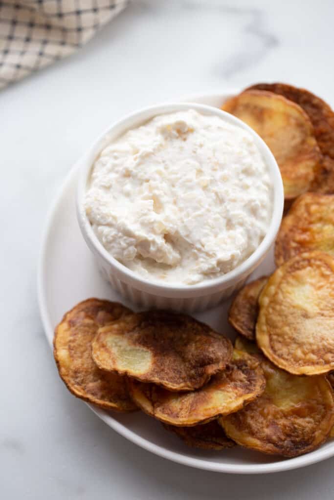 Air Fryer potato chips on a plate with a small bowl of homemade dip made with Greek yogurt. 