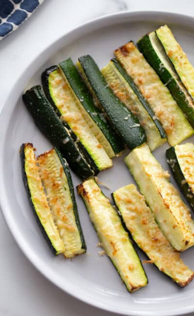 A plate of zucchini topped with crispy parmesan cheese