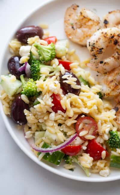 Overhead close up image of orzo salad on a white plate