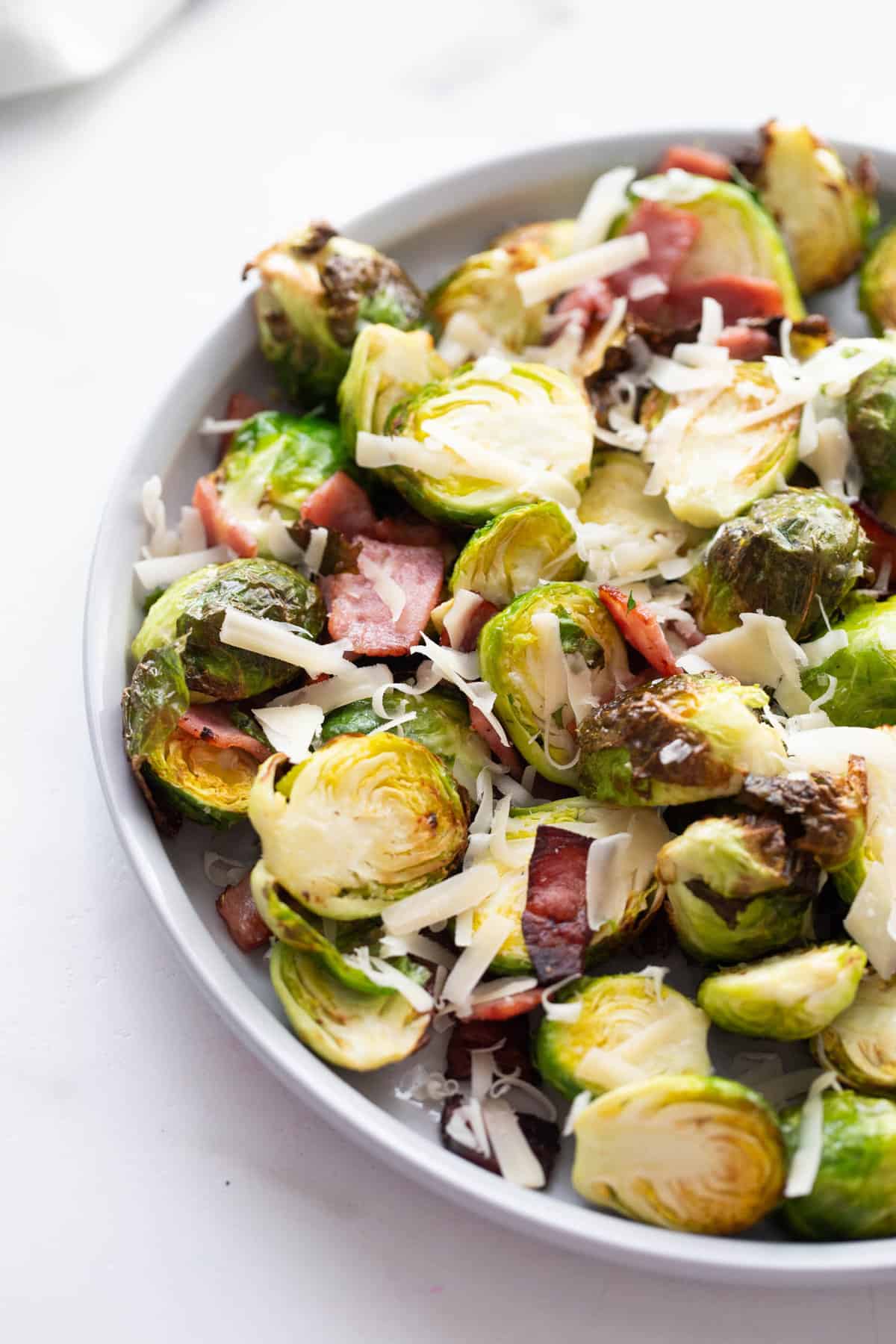 A plate of Air Fryer Brussels Sprouts with turkey bacon and parmesan cheese.