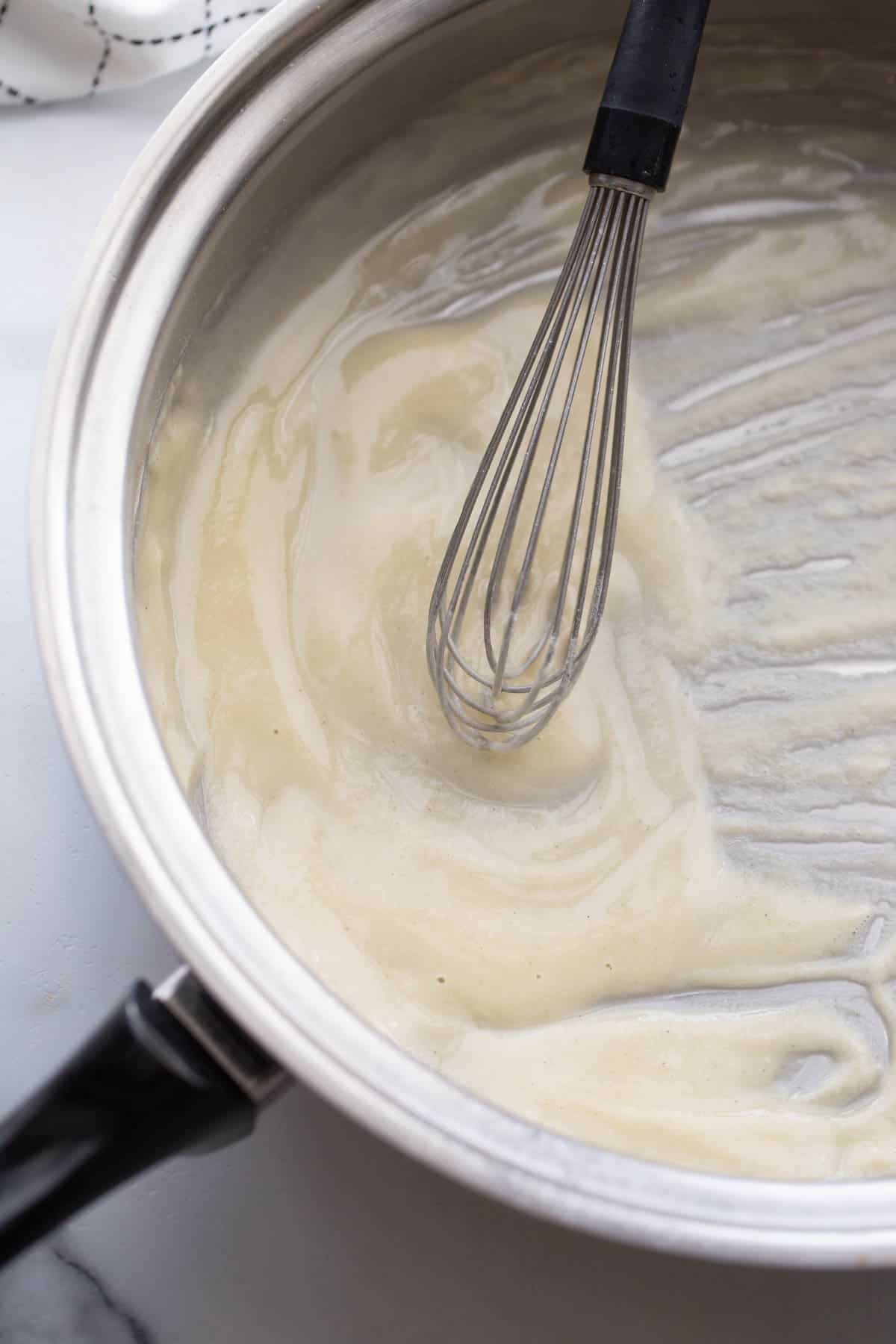 Butter and flour roux in a pan with a wire whisk