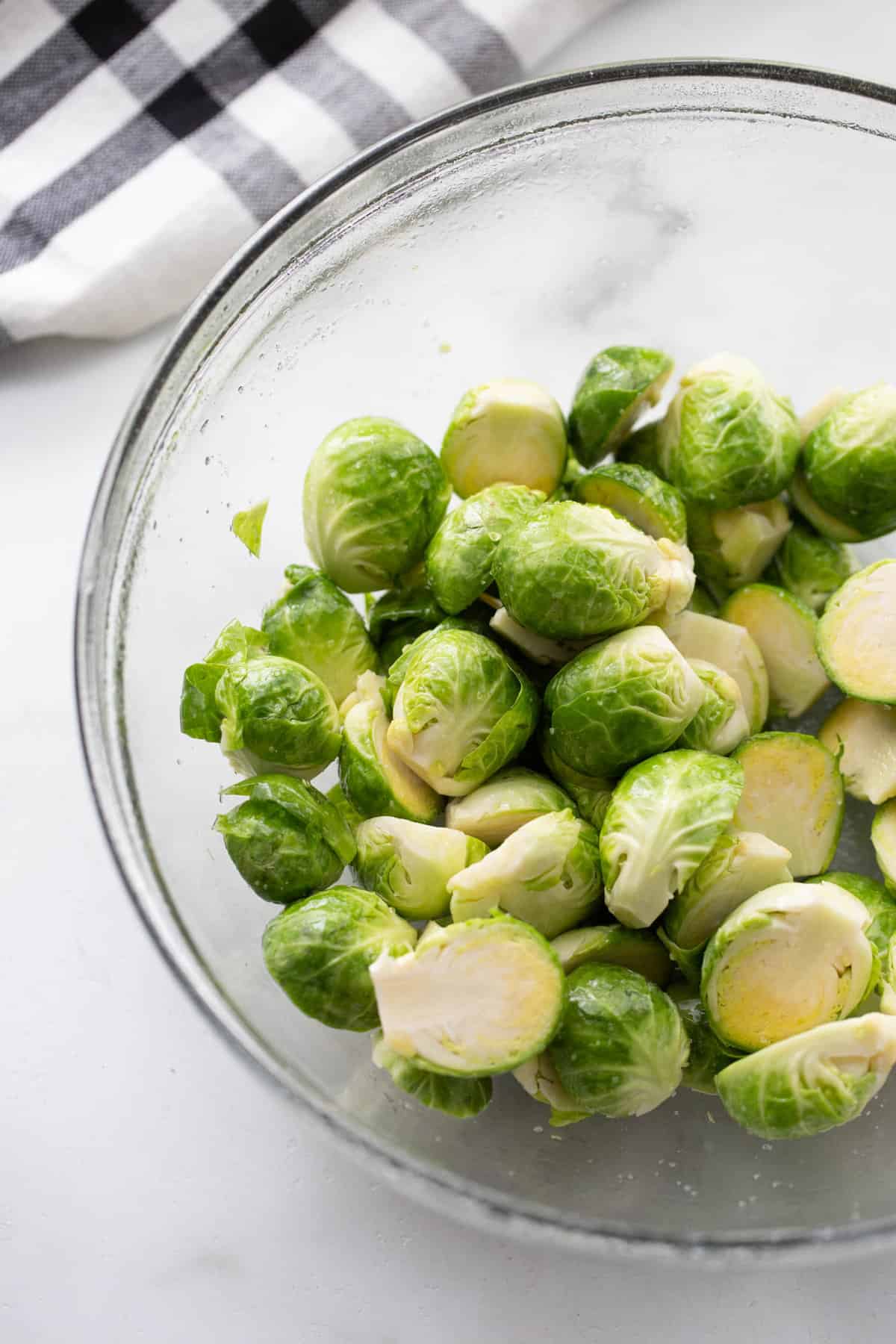 A bowl of Brussels sprouts coated in oil and kosher salt.