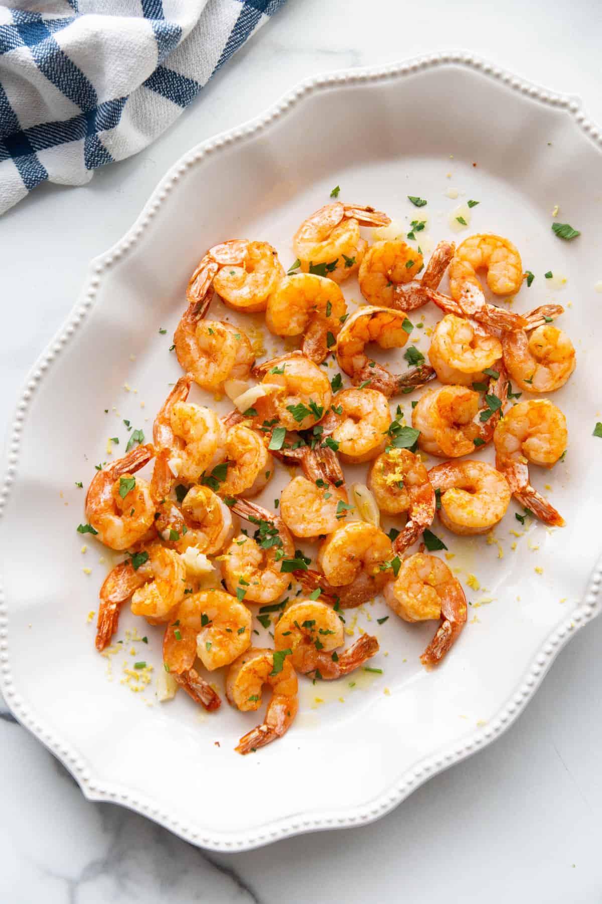 Overhead shot of Air Fryer Shrimp on a pretty white platter with scalloped edges.