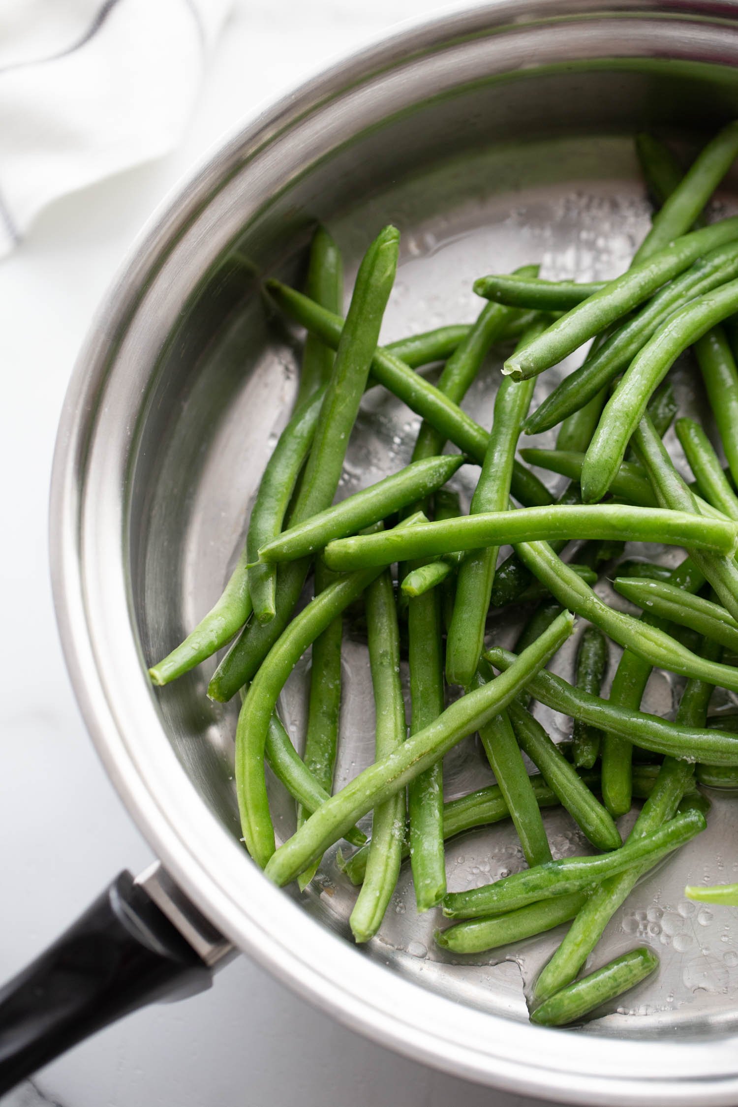 Skillet with green beans and water.