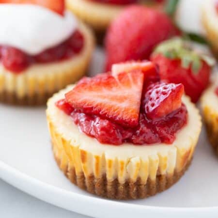 Close up of a mini cheesecake topped with strawberries.