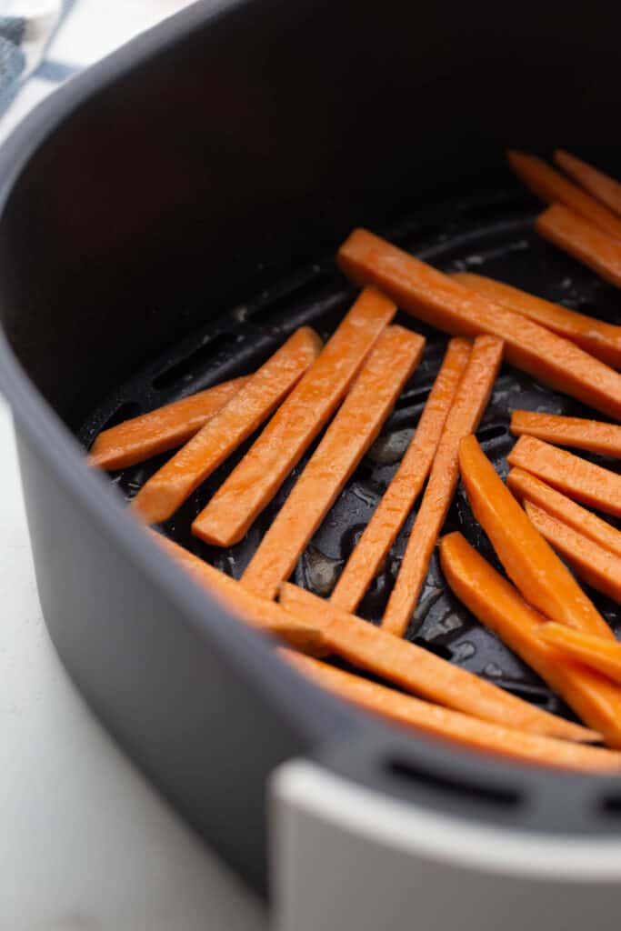 Homemade Sweet Potato Fries in an air fryer basket.