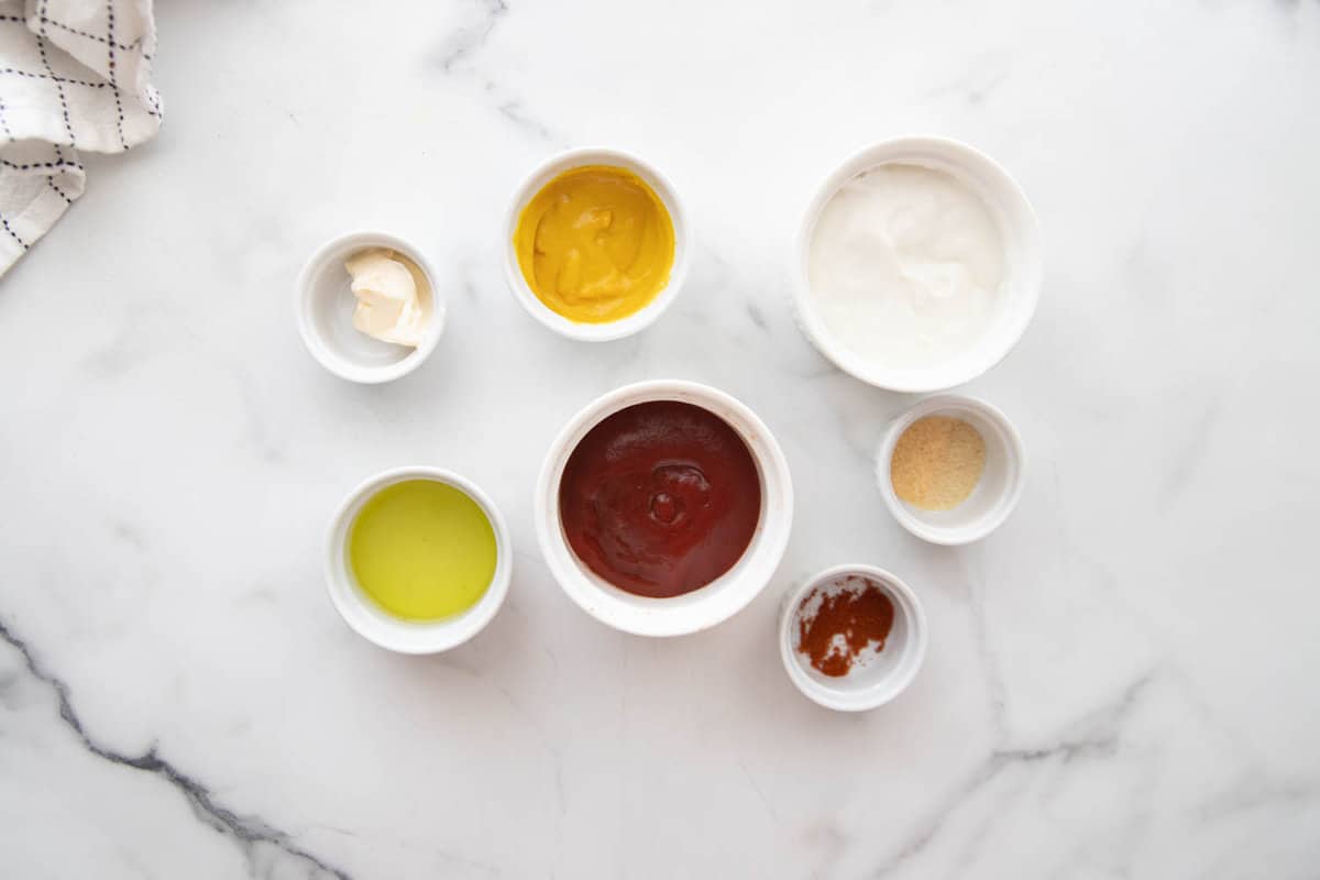 Ingredients for special sauce for burgers made with ketchup, Greek yogurt, mustard, pickle juice, and seasonings.