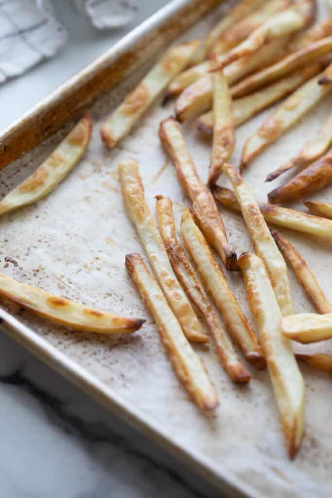 A tray of crispy homemade baked french fries.